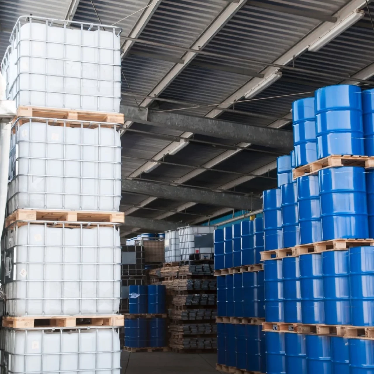 utility crates and drums stacked on each other in the warehouse